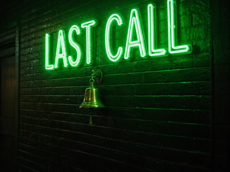 A green neon sign reading Last Call above a brass bell on a wet brick wall